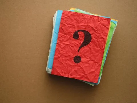 Top view of a dark question mark printed on a crumpled red piece of paper Stock Photos
