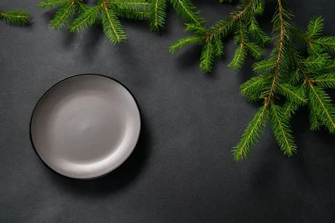 Top View Dark Table with Empty Plate. Green Christmas Branch lies with shadow Stock Photos