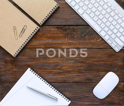 Top view of dark wooden Desk with Keyboard and stationery Stock Photos
