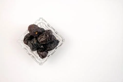 Top view of dates on glassware over white. Stock Photos