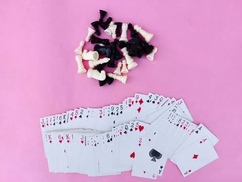 Top view .Deck of playing cards and chess pieces isolated on pink background Stock Photos