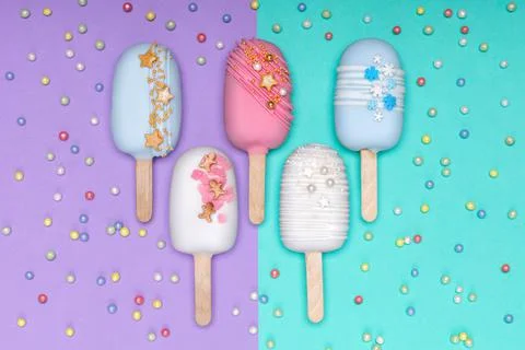 Top view of decorated cake pops ice creams on violet and turquoise background Stock-Fotos
