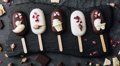 Top view of decorated cake pops ice creams on black background Stock Photos