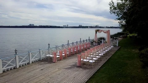 Top view of a decorated pink wedding ceremony on a wooden pier near the sea. Stock Footage 121621160