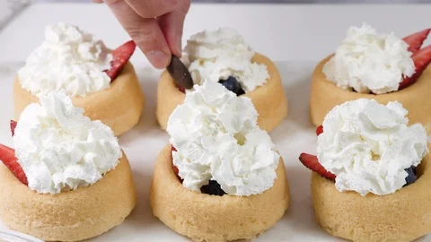 Top view of decorating biscuits with whipped heavy cream and chocolate Stock Footage 125412821
