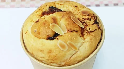 Top view of a delicious round raisin bread topped with almond flakes. Stock Footage 345819138