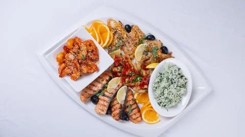 Top view of a delicious seafood and rice dish on a white platter with an or.. Stock Photos