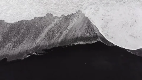 Top view of a deserted black volcanic beach. Drone shot, directly above black Stock Footage 106439124