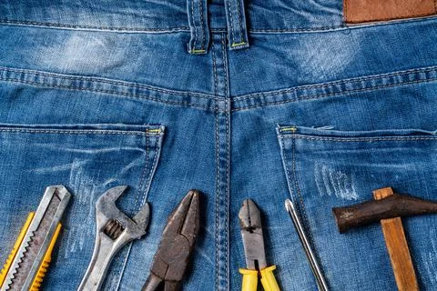 Top view design concept of Labor Day with working tools and jeans. Stock Photos