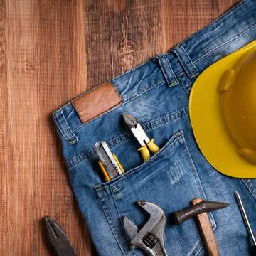 Top view design concept of Labor Day with working tools and jeans. Stock Photos