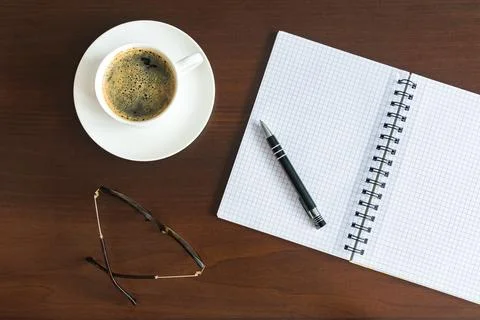 Top view of a desk with blank notepad and cup of coffee Stock Photos