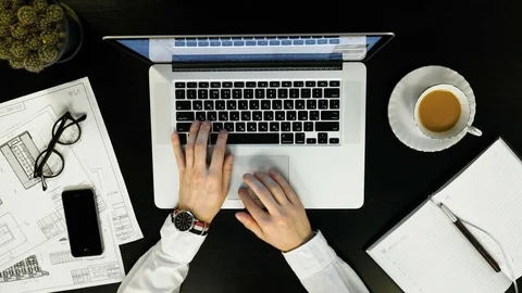 Top view of desk. Man typing on his laptop and drinking coffee Video stock 74424124