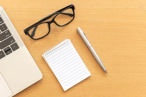 Top view desk with notepad and laptop on office wooden table Stock Photos