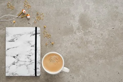 Top view of desk with notepad, coffee cup, earphones, pen and staples. Flat lay Stock Photos