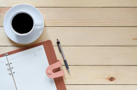 Top view desk work with coffee cup, pen, leather notebook and copy space. Stock Photos