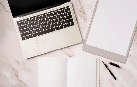 Top view desktop blank calendar, notebook and laptop on light gray marble bac Stock Photos