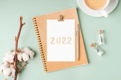 Top view Desktop Christmas notepad with 2022 text. Flat lay on green mint table Stock Photos