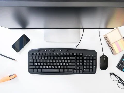 Top view of Desktop computer with office supplies on white background. Stock Photos