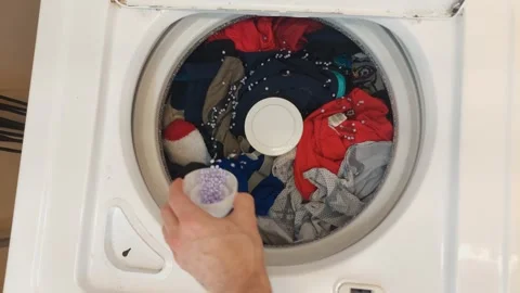 Top view of detergent and scent beads to washing machine Stock Footage 257267135