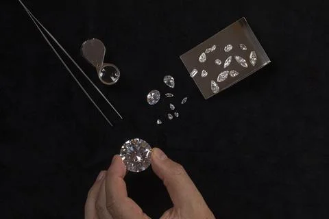 Top view of Diamonds of different cuts and sizes scattered on table with a Stock Photos