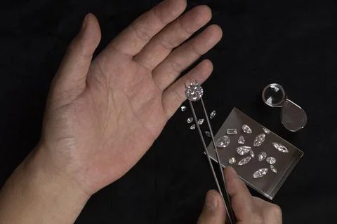 Top view of Diamonds of different cuts and sizes scattered on table with a Stock Photos