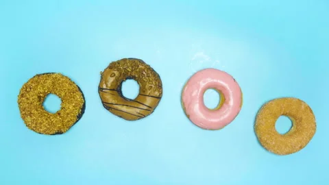 Top view different donuts colors changing at blue background. Stock Footage 244630421