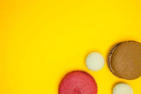 Top view of different flavors macroons over yellow background Fotos Stock