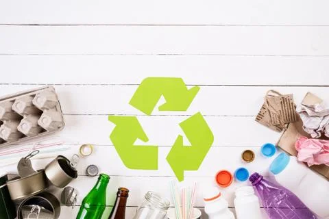 Top view of Different garbage materials with recycling symbol on white wooden Stock Photos