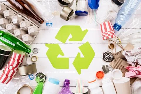 Top view of Different garbage materials with recycling symbol on white wooden Stock Photos