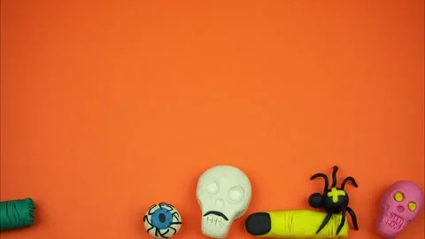 Top view of different scary things falling down on orange background.Stop motion Video stock 252937999