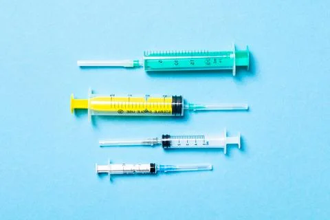 Top view of different syringes at blue background. Medical injection concep.. Фото