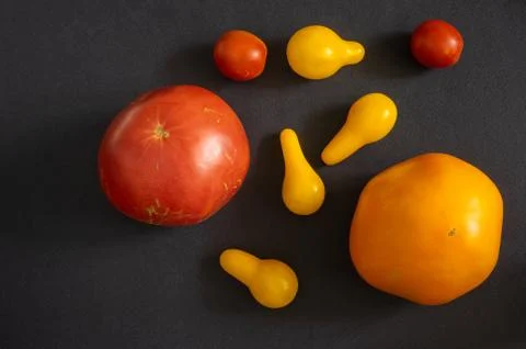 Top view on different type of organic tomatoes lying on a black background Foto stock