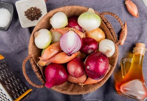 Top view of different types of onion in basket with salt black pepper seeds m Stock Photos