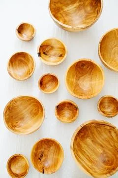 Top view on differently sized handmade wooden bowls on a white surface Stock Photos