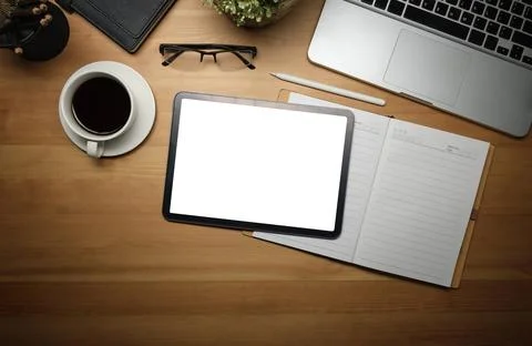 Top view of digital tablet, coffee cup, eyeglasses and notebook on wooden w.. Foto stock