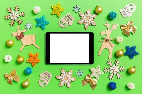 Top view of digital tablet on green background with New Year toys and decorat Stock Photos