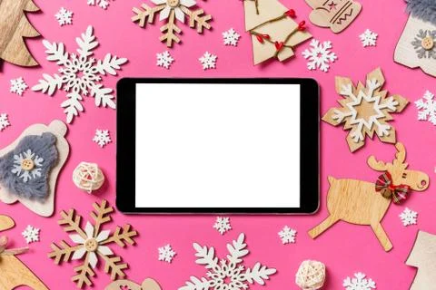 Top view of digital tablet on pink background made of holiday decorations and Stock Photos