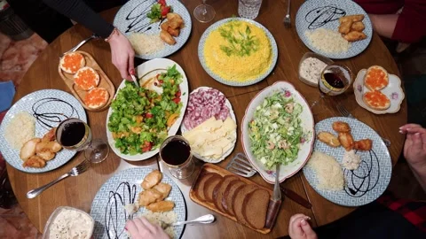 Top view of a dining table with various delicious dishes. The hands of unreco Stock Footage 221127152