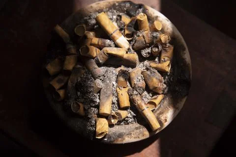 Top View dirty ashtray full of cigarette butts with contrast light Foto stock