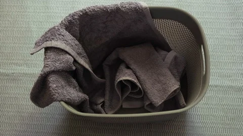 Top view: Dirty clothes are filling a laundry basket on a floor. Stop Motion Stock-Footage 197604885