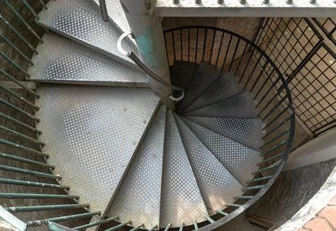 Top view of the distinctive metal steps and railing of steel spiral stairca.. Stock Photos