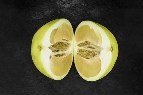 Top view of divided in the half pomelo fruit and placed on black stone backgr Stock Photos