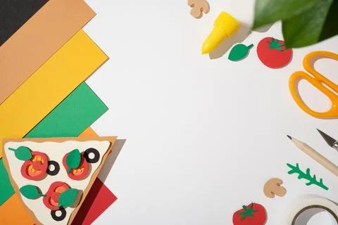 Top view of DIY craft project pizza on white background with scissors, penc.. 库存照片