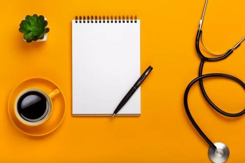 Top view on doctor's desk with notepad and stethoscope, prescription and cup  Stock Photos