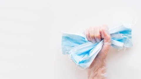 Top view on doctor's hand grasping pack of blue protective medical masks. Cor Stock Photos