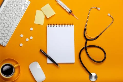 Top view of a doctor's table with notepad and pen stethoscope, keyboard, pres Stock Photos