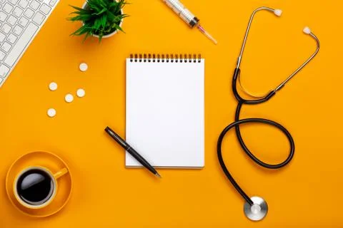 Top view of a doctor's table with notepad and pen stethoscope, keyboard, pres Stock Photos