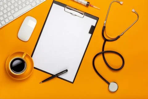 Top view of a doctor's table with notepad and pen stethoscope, keyboard, pres Stock Photos