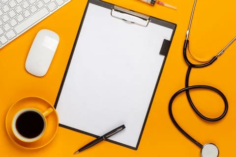 Top view of a doctor's table with notepad and pen stethoscope, keyboard, pres Stock Photos
