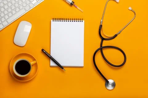 Top view of a doctor's table with notepad and pen stethoscope, keyboard, pres Stock Photos